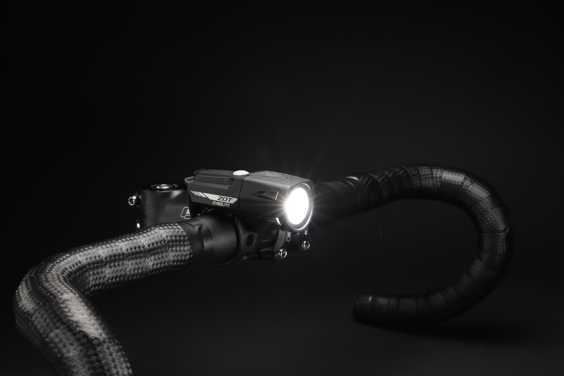 Cygolite Zot headlight lit on road bike handlebars
