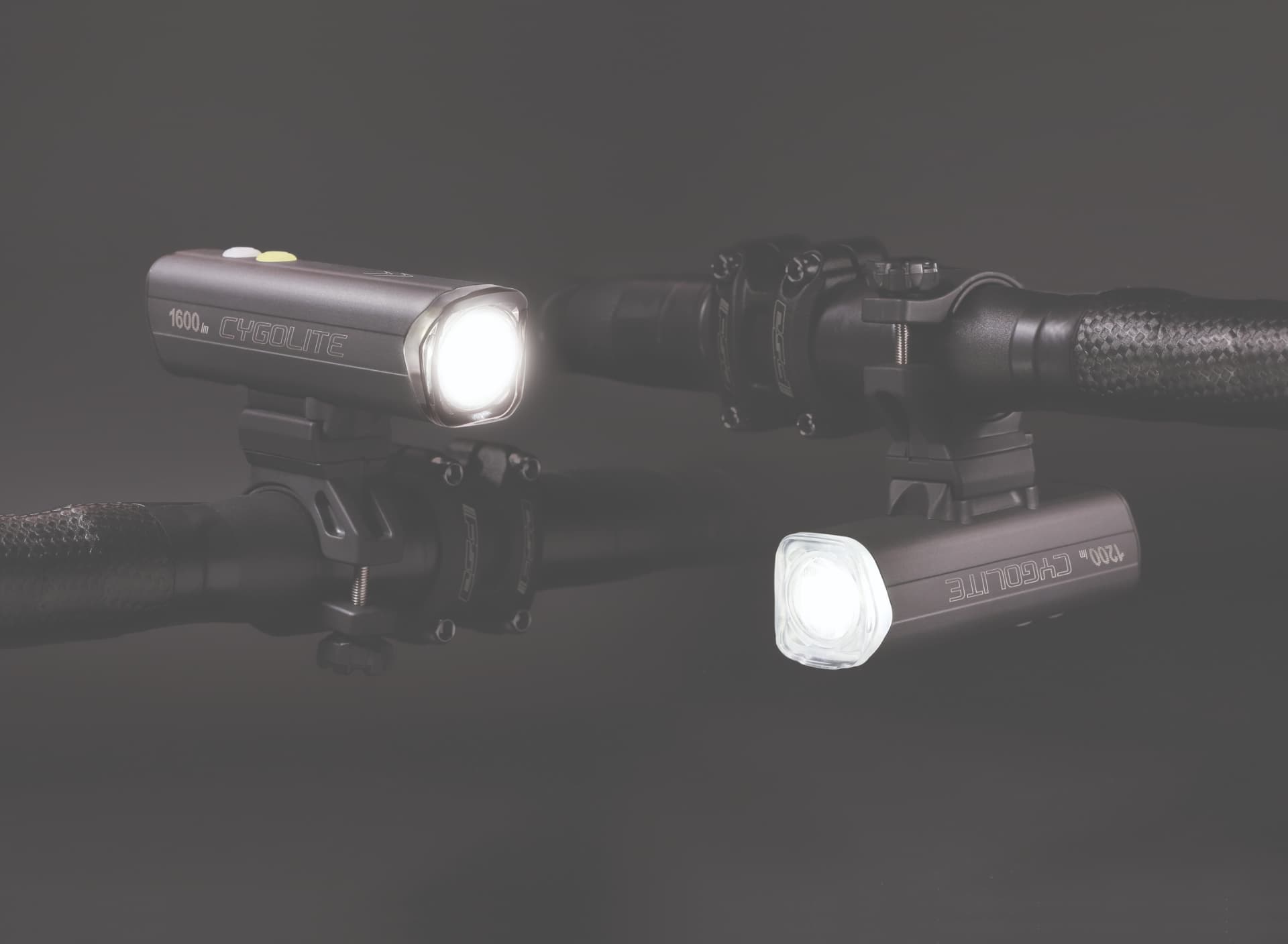 Two Cygolite headlights mounted above and below the handlebars, beams lit